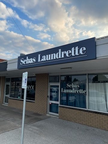 Sebas Laundrette navy shop sign in daylight