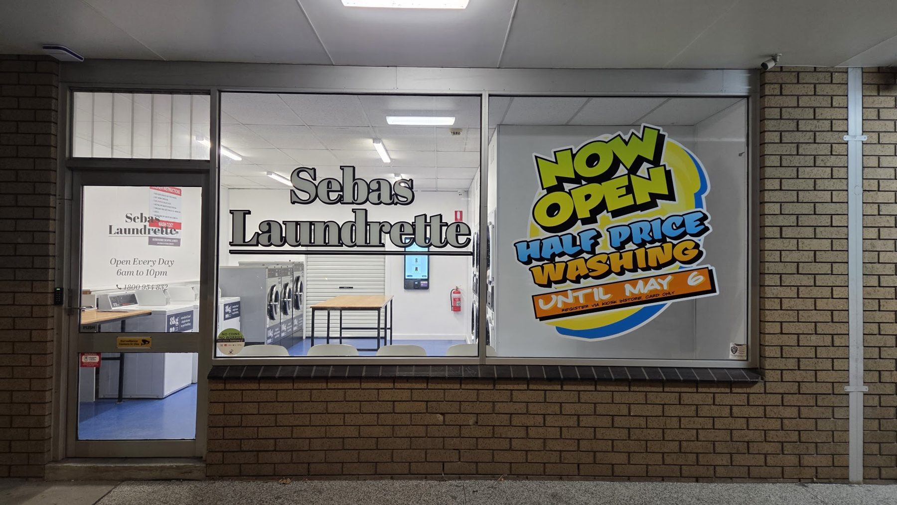 Front window of Sebas Laundrette looking in on the washers and folding table