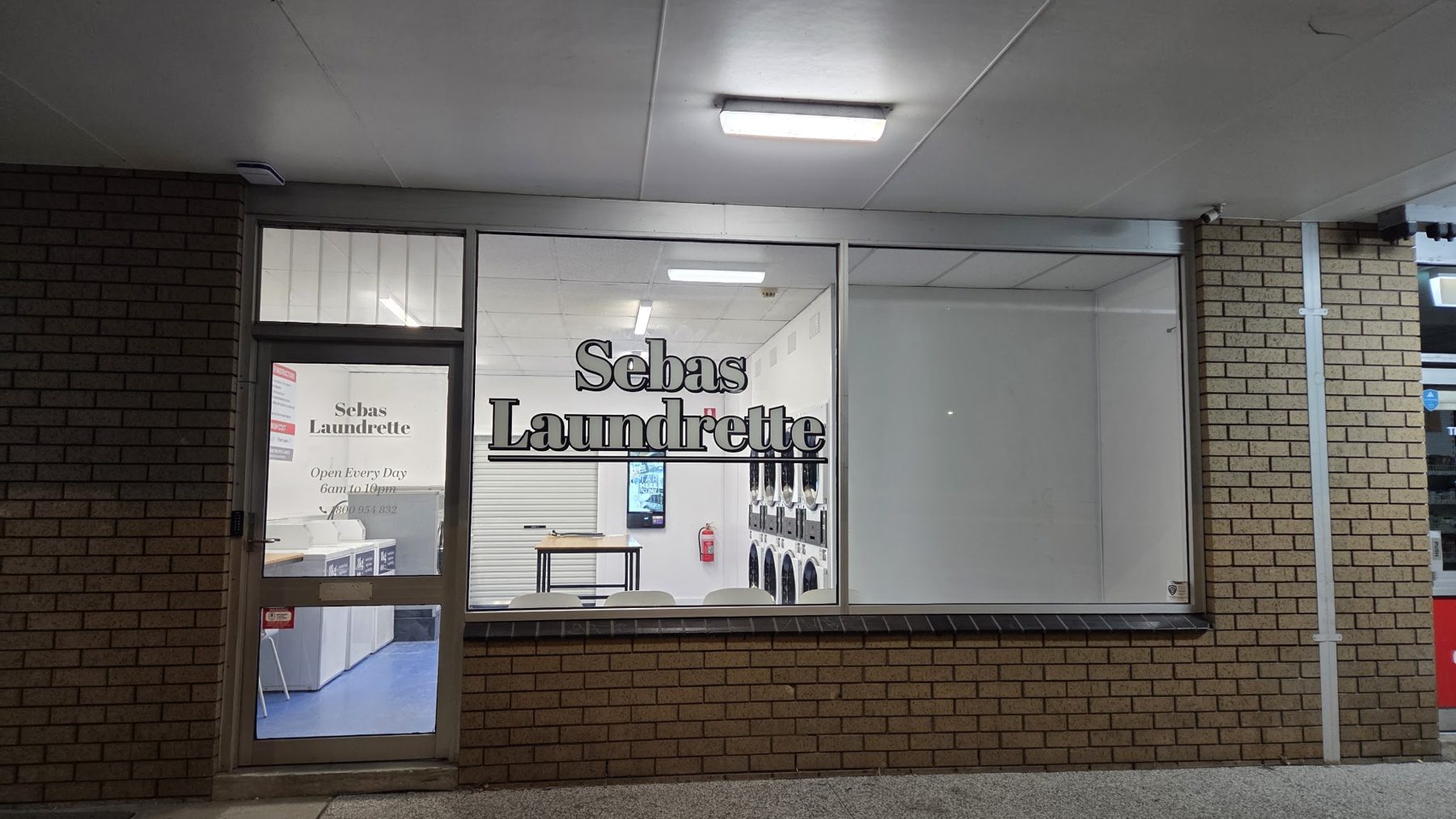 Sebas Laundrette front door with its Open Every Day 6am to 10pm sign